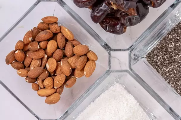 Peanut butter Almonds Coconut Chia Seeds and Dates in the bowls (Flip 2019)