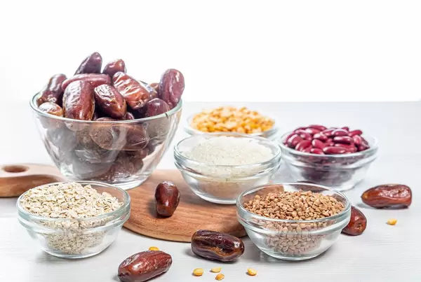 Peas, beans, buckwheat, oatmeal, rice and dried dates on the white table