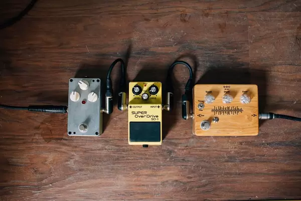 Pedal und weitere Technik zu elektrischer Gitarre auf Holzboden