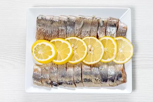 Peeled fillet of pickled herring with lemon slices (Flip 2019)