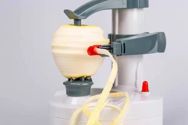 Peeling an apple in an electric peeler