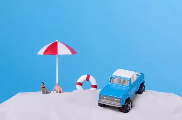 People and off-road car on the sandy beach