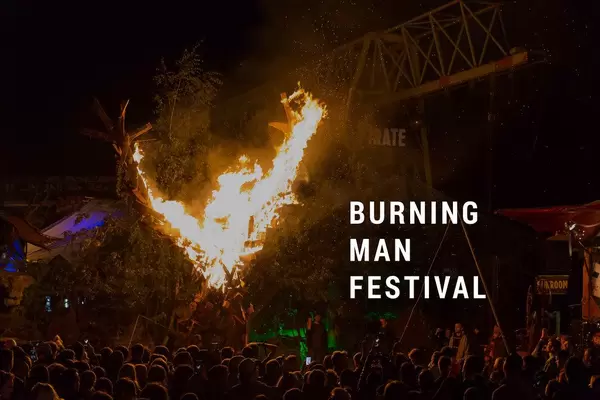 People at Hippie Festival watching the Burning Man burst into flames, in Black Rock City, in the middle of the desert of Nevada