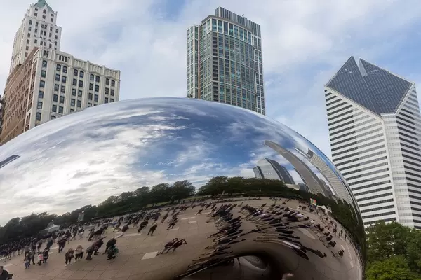 People, cloudy sky and skyscrapers reflected in the Cloud Gate sculpture by Anish Kapoor at Millennium Park in Chicago