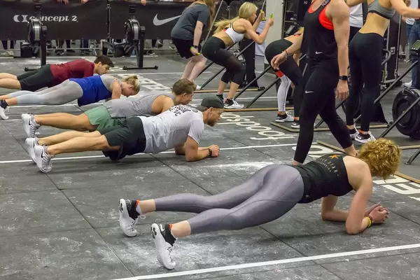 People doing a plank next to each other while others do different exercises