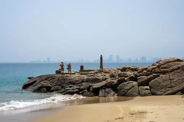 People on a large Rock at a Sand Beach on Son Tra Peninsula overlooking East Vietnam Sea and the City of Da Nang in Vietnam