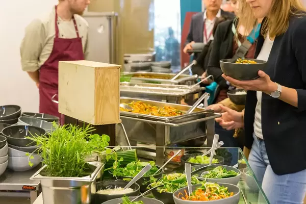 People queuing for a healthy balanced lunch meal with salad bar at the buffet of AXA's Barcamp OMWest19 in Cologne, Germany