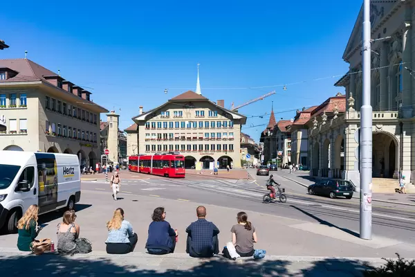 People sitting down on stairs and relaxing in the historical center of Bern, Switzerland