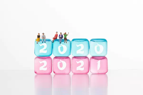 People sitting on ice cubes with 2020 and 2021 text