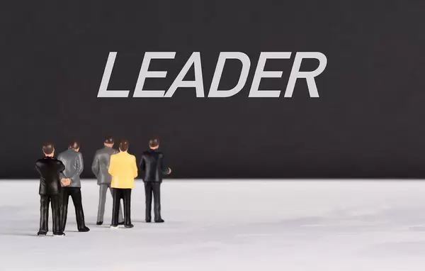 People standing in front of Leader text
