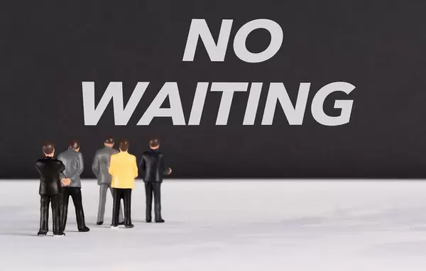 People standing in front of No Waiting text