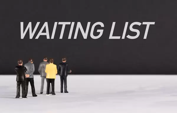 People standing in front of Waiting List text