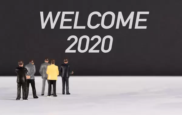 People standing in front of Welcome 2020 text