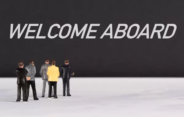 People standing in front of Welcome Aboard text