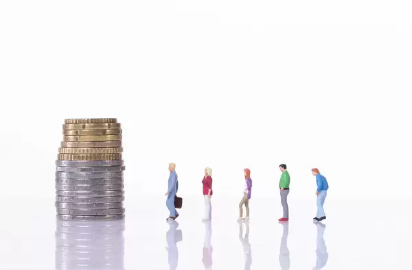 People standing in line in front of coin stack