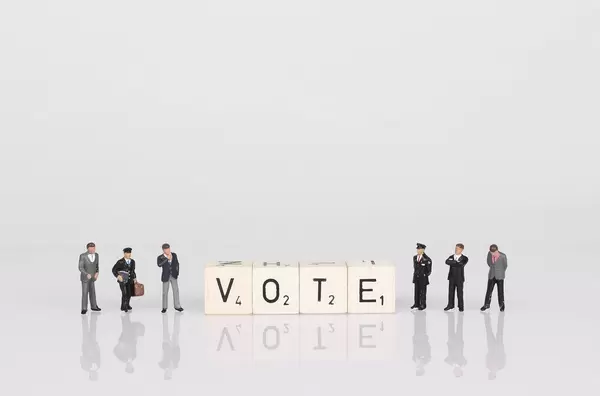 People standing next to vote text