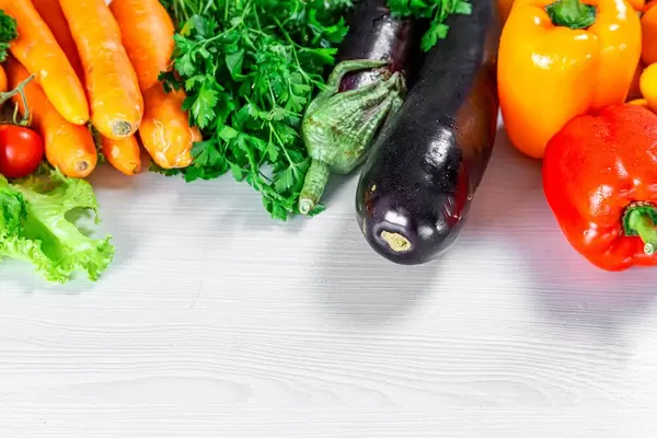 Pepper, eggplant, parsley and carrot on white wooden background (Flip 2019)