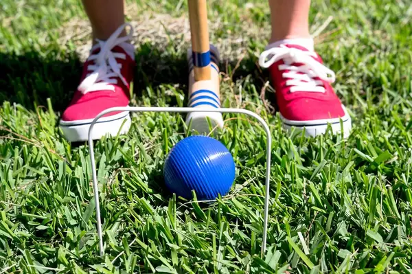 Person about to hit croquet ball