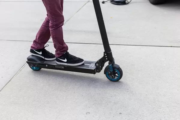 Person driving Egret One Electric Scooter on a paved way