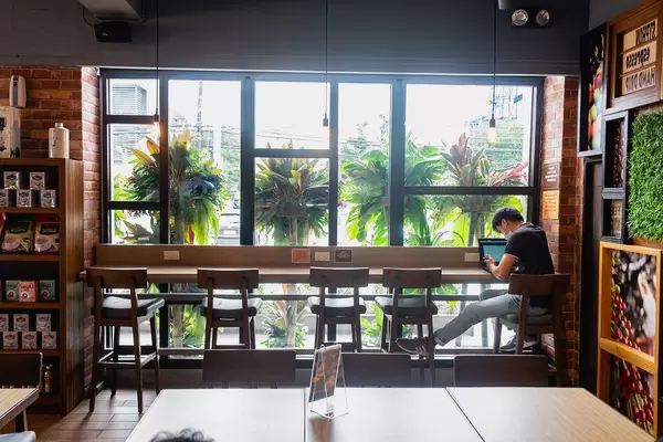 Person sitting on counter table at a local coffee shop in Bacolod (Flip 2019)