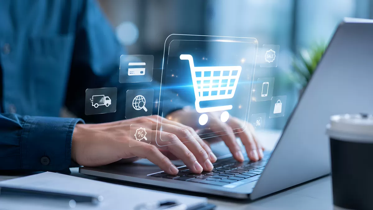 Person tippt auf Laptop mit digitalen Einkaufssymbolen