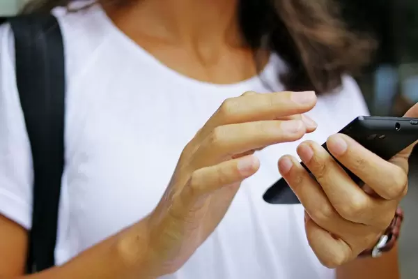 Person walking on the street and playing with the Phone