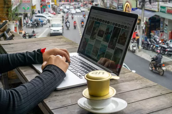 Person working online on a Laptop at a Cafe with Vietnamese Hot Coffee in Vietnam