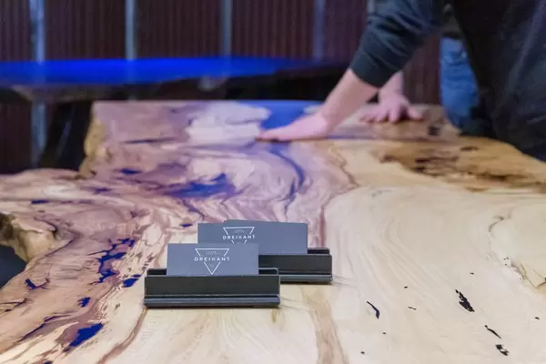 Personen fühlen Struktur eines Tisches aus Baumstamm mit auffälliger Maserung