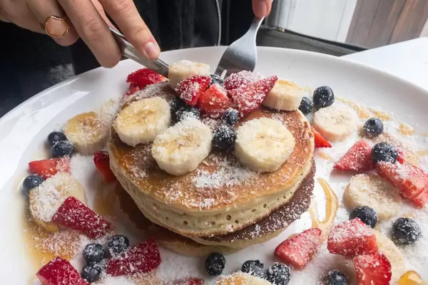 Pfannkuchen mit Banane, Erdbeere, Blaubeere und Kokosraspeln