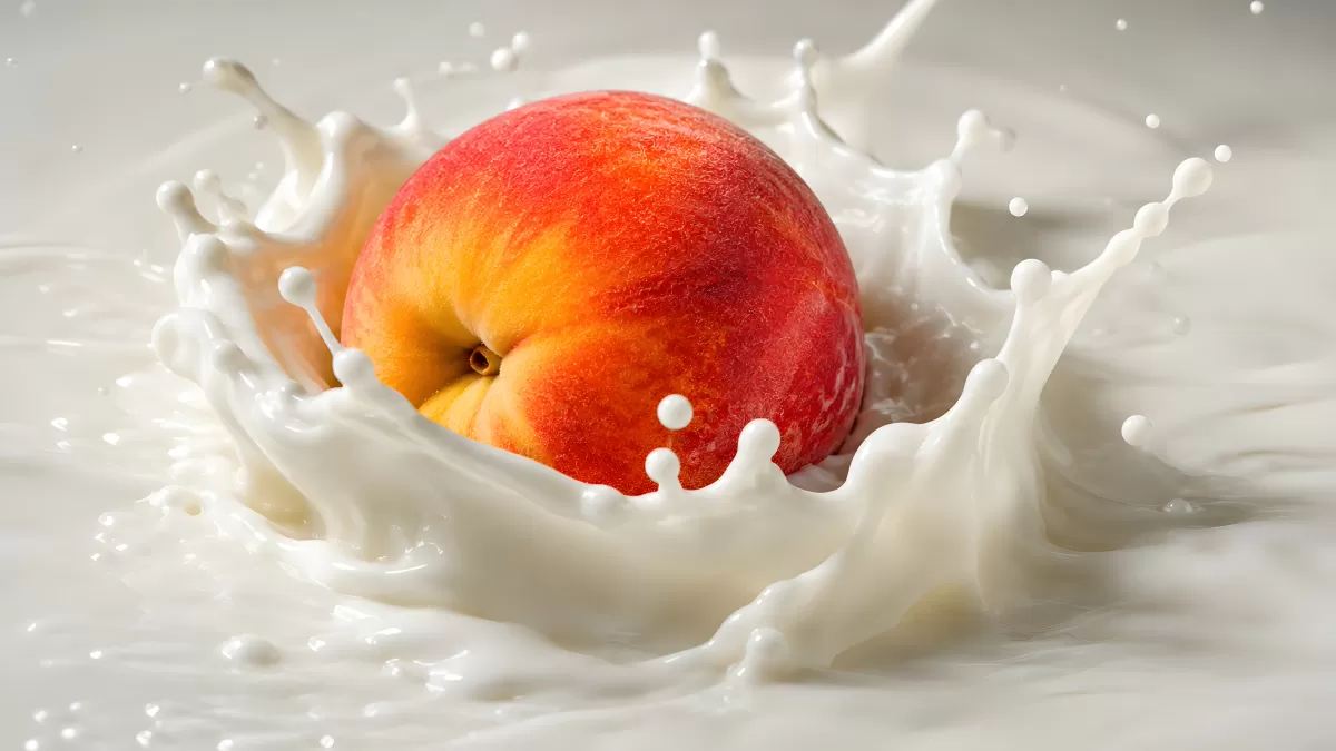 Pfirsich planscht in Milch – Spritzwasser-Aufnahme