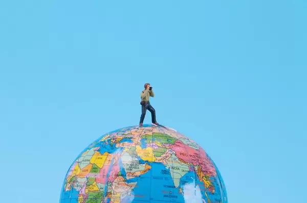 Photographer standing at top of the globe