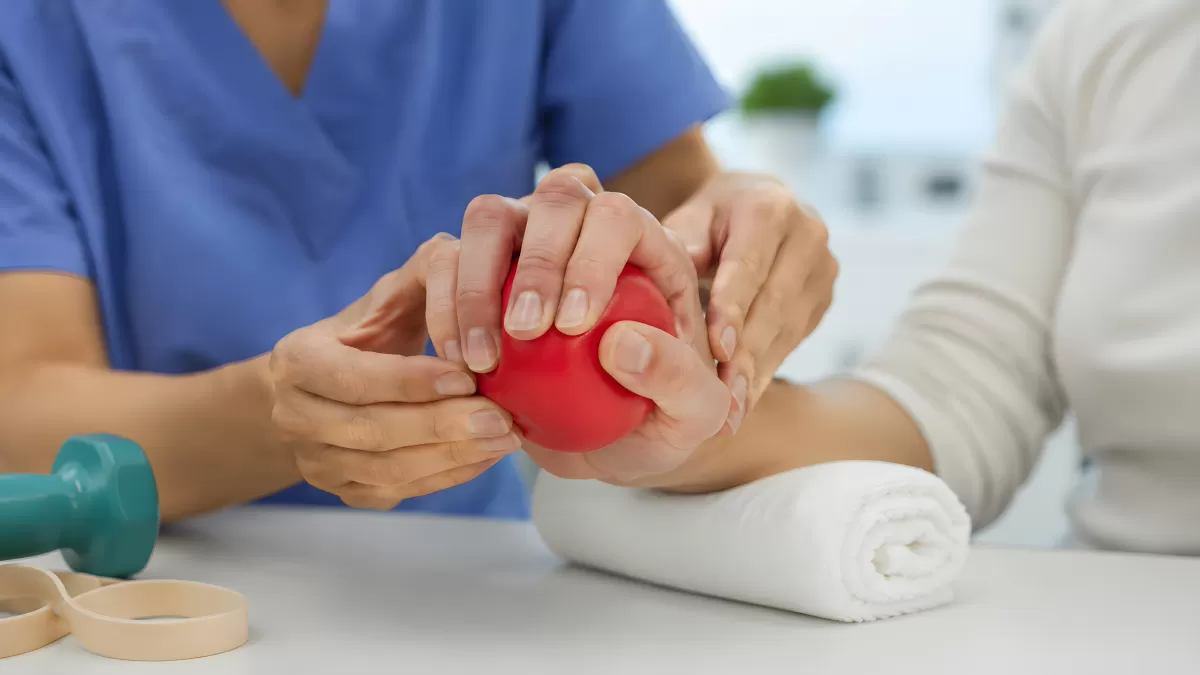 Physiotherapeutin unterstützt Patientin bei Handübung