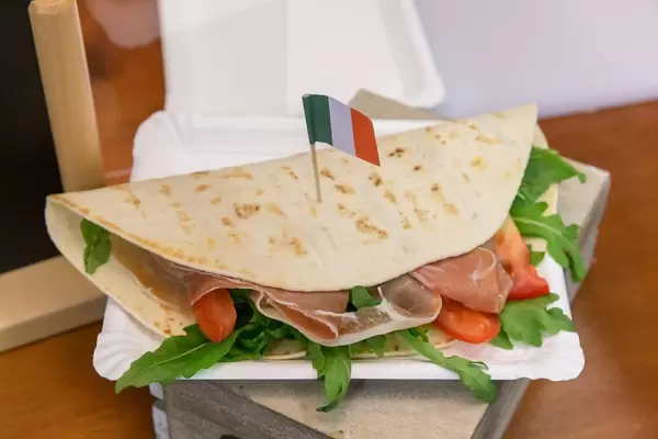 Piadina Romangola - Flatbread - with Parma ham, arugula, tomatoes, cream cheese, pesto, mozzarella and Italy flag