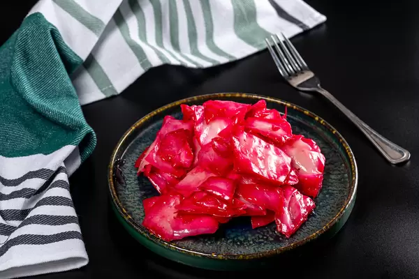 Pickled cabbage with beetroot on a black background