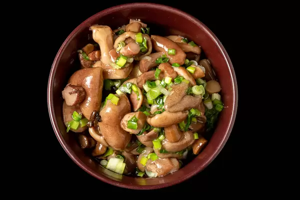 Pickled forest mushrooms on a dark background, top view