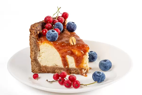 Piece homemade cheesecake with red currant and blueberry