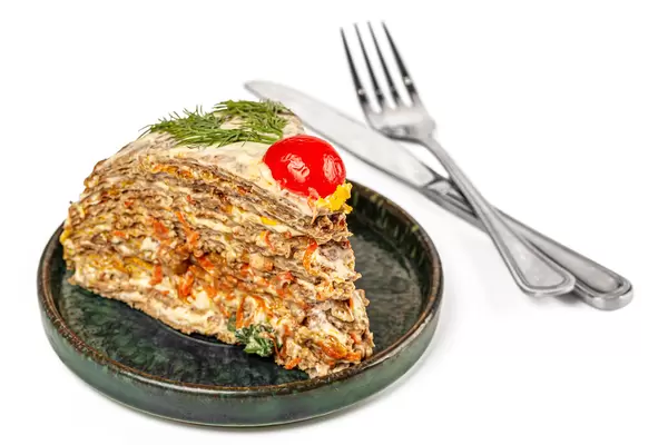 Piece liver cake with carrot, garlic and dill on a plate