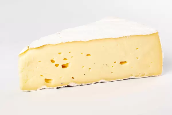 Piece of brie cheese on white background