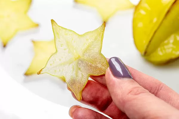 Piece of fruit carambola in a woman's hand (Flip 2019)