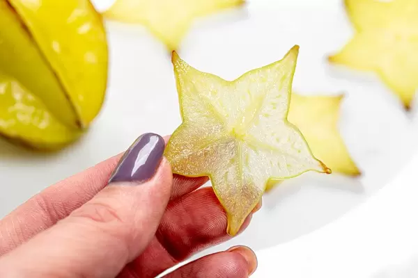 Piece of fruit carambola in a woman's hand