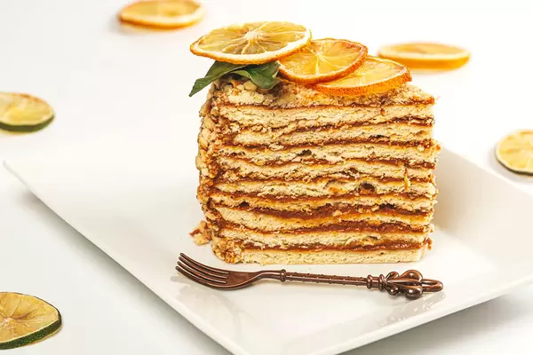 Piece of honey cake with pieces of dried citrus fruits