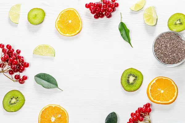 Pieces of fresh fruit, berries and green leaves with Chia seeds on a white wooden background. Top view (Flip 2019)