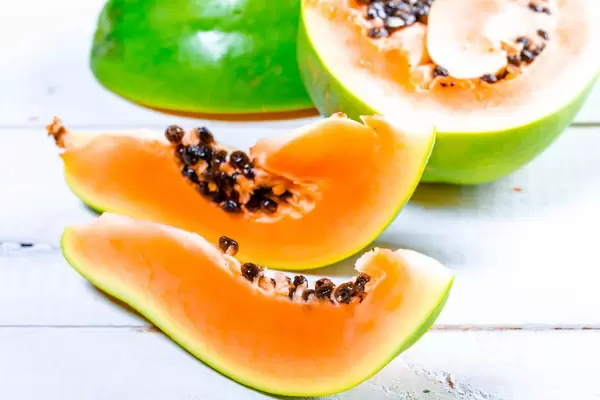 Pieces of fresh ripe papaya on white wooden background (Flip 2019)