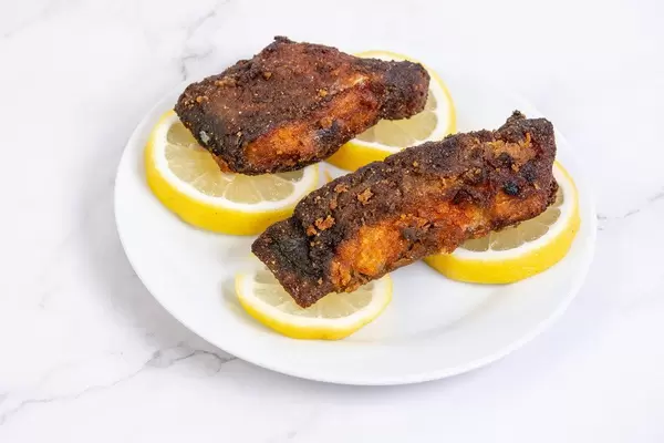 Pieces of fried Carp fish with Lemons on the plate