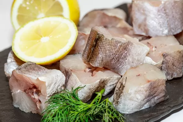 Pieces of raw fish hake with herbs and lemon  Flip 2019