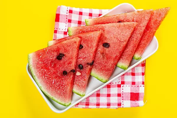 Pieces of ripe fresh watermelon on a yellow background with a kitchen towel (Flip 2019)