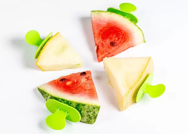 Pieces of ripe melon and watermelon on ice cream sticks