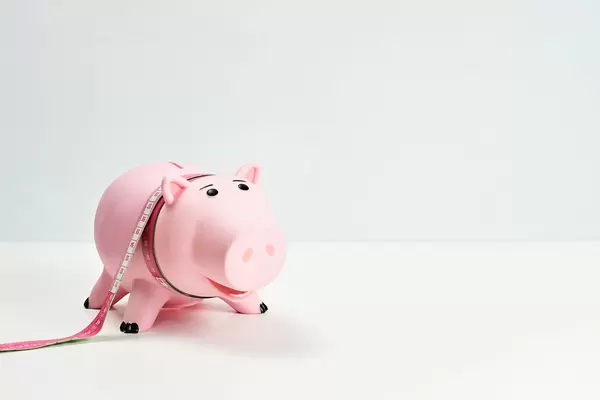 Piggy bank and measuring tape - Dieting concept