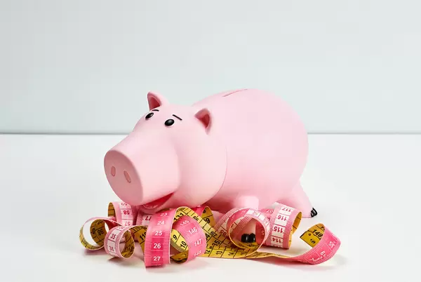 Piggy bank surrounded by unwound tapes