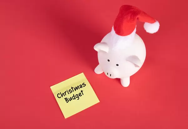 Piggy bank with Christmas hat and sticky note with Christmas Budget text